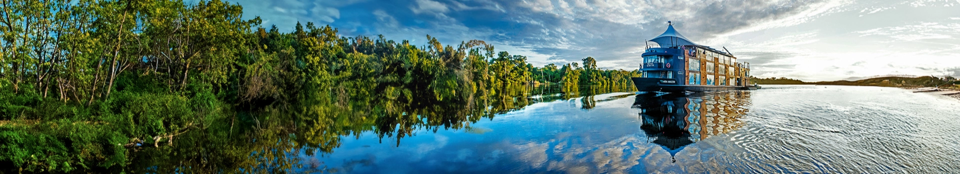 Un crucero de turistas navega por un río, simbolizando la experiencia de turismo en la naturaleza