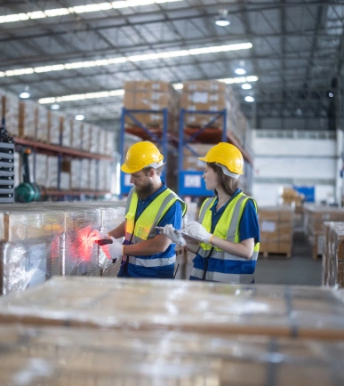 Dos operarios logísticos trabajando en un almacén