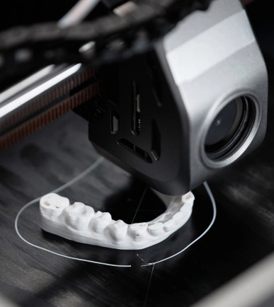 Impresora 3D fabricando una dentadura, simbolizando un proyecto tecnológico innovador